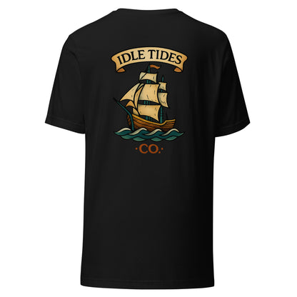 Black tee with Idle Tides ship graphic on back and crest badge on front