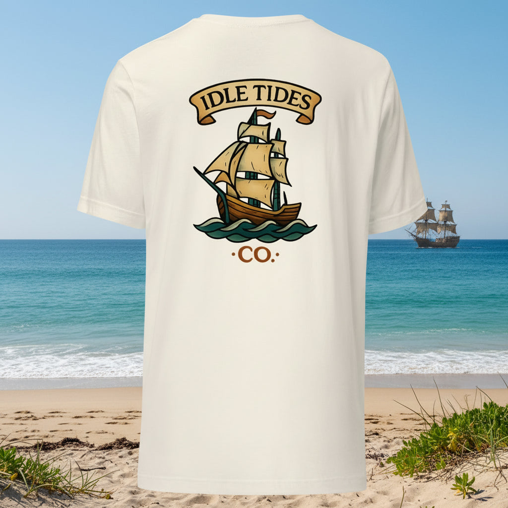 Sand tee with Idle Tides ship graphic on back and crest badge on front