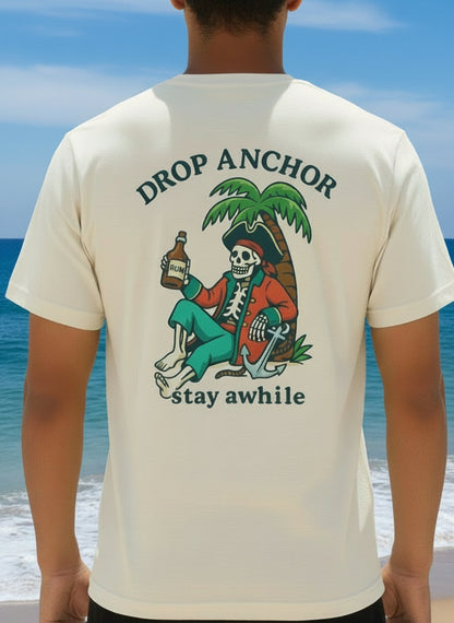 Idle Tides Co ‘Drop Anchor, Stay Awhile’ crewneck tee in vintage white with nautical text graphic across chest, relaxed fit, and dockside lifestyle design.
