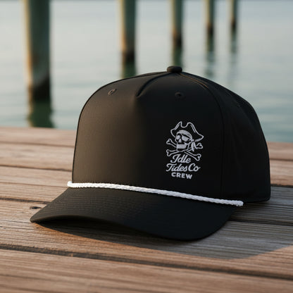 Idle Tides Crew Rope Cap in matte black with white embroidered skull crest, crossed bones, and ‘Idle Tides Co CREW’ text; features white braided rope detail across brim.